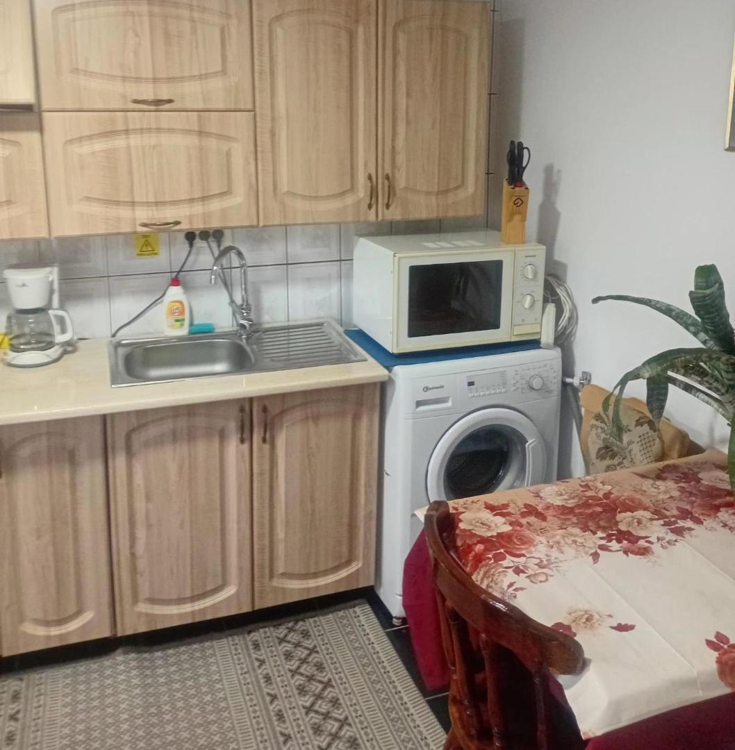 Bucătăria cu chiuvetă, microunde, mașină de spălat și masă
