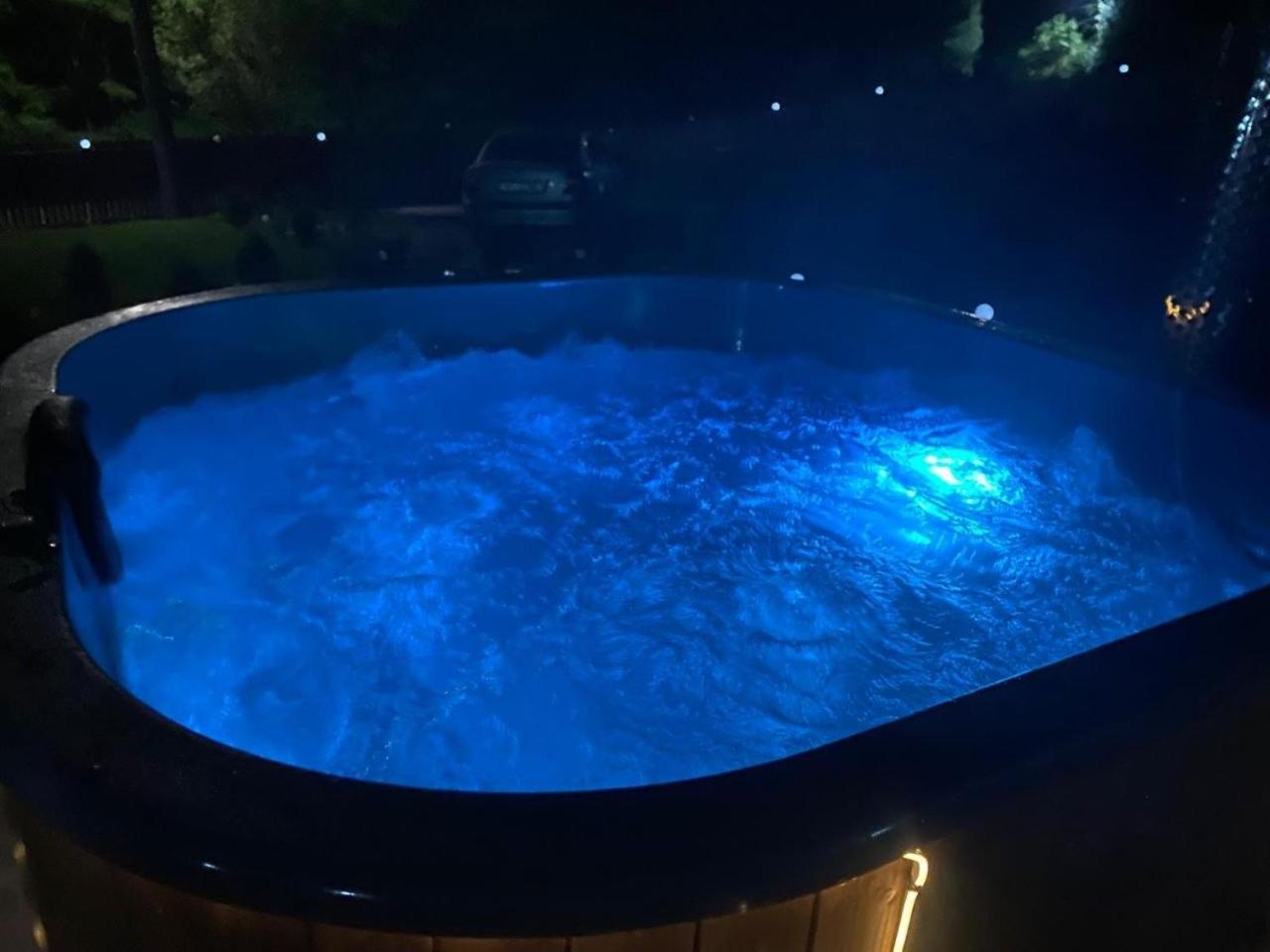 Ciubăr cu hidromasaj, luminat seara, în curtea complexului