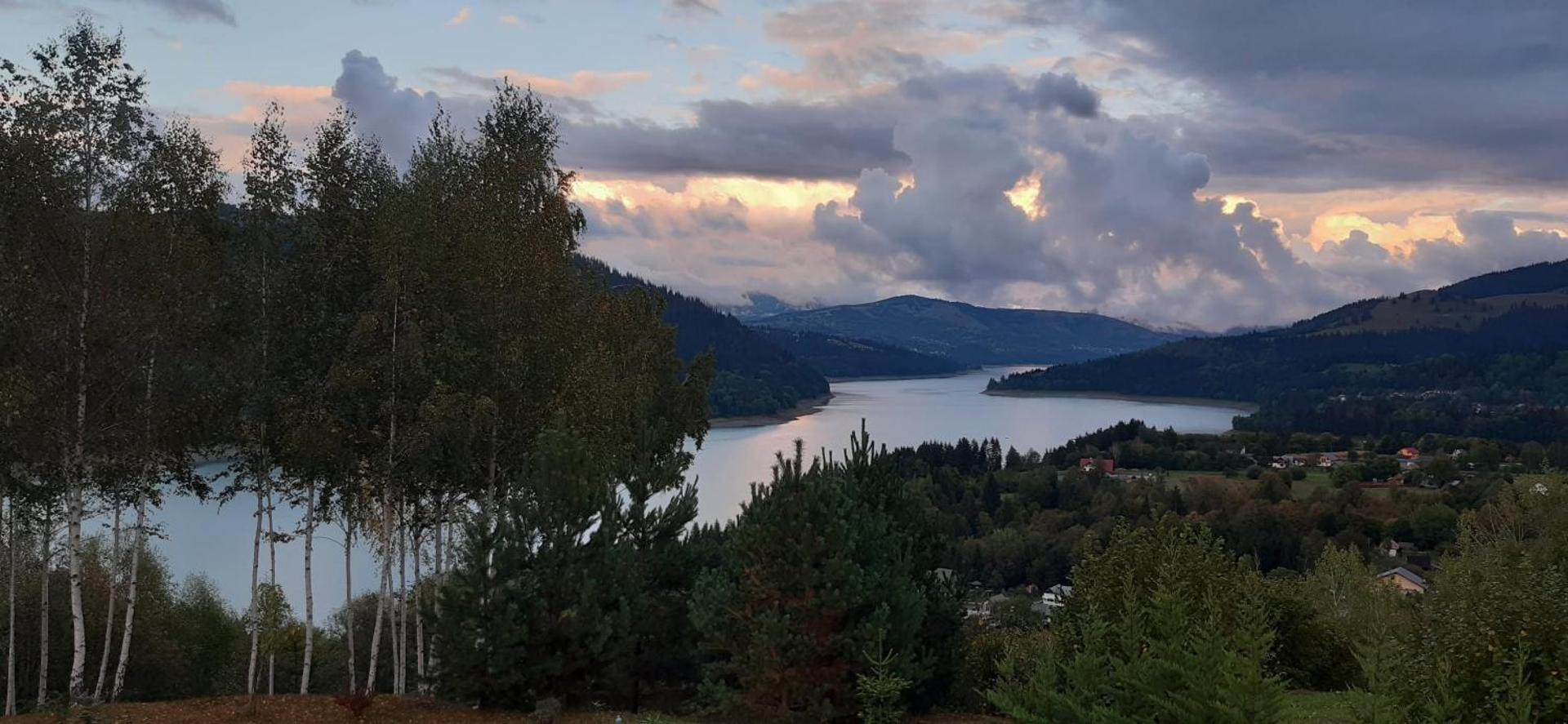 Panoramă cu lacul și munții la apus